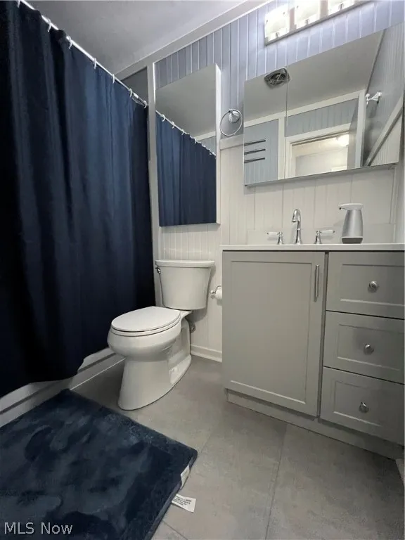 Bathroom with vanity, toilet, and concrete flooring