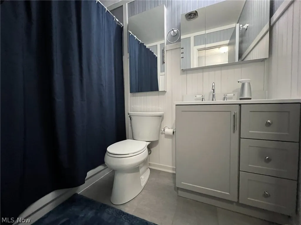 Bathroom with vanity, toilet, and tile patterned flooring