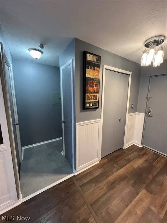 Corridor with dark carpet and a textured ceiling