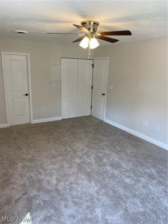 Unfurnished bedroom featuring carpet and ceiling fan