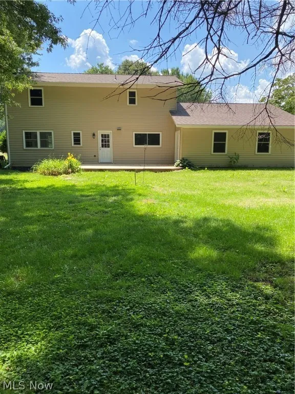 Rear view of house with a lawn
