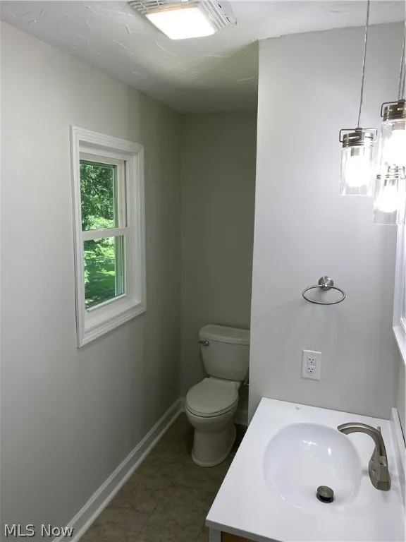 Bathroom with tile patterned floors, toilet, and vanity