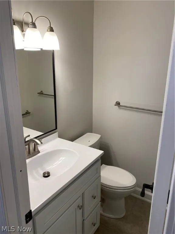 Bathroom featuring vanity, tile patterned flooring, and toilet