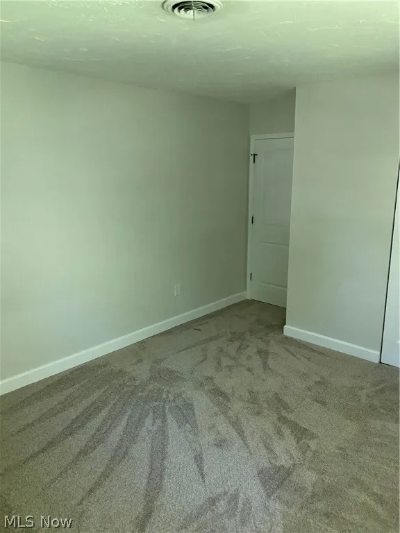 Empty room with dark colored carpet