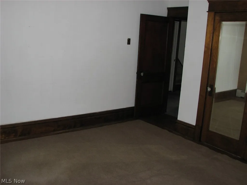 Unfurnished room with dark colored carpet