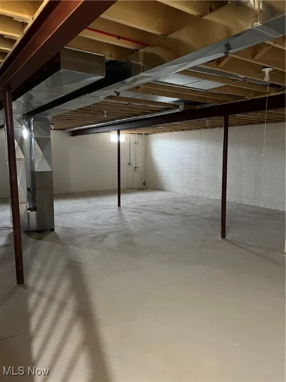 Unfinished below grade area featuring heating unit