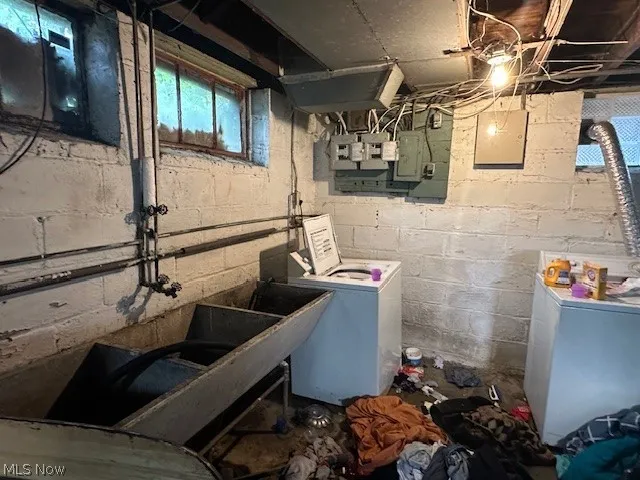 Basement with washing machine and clothes dryer and electric panel