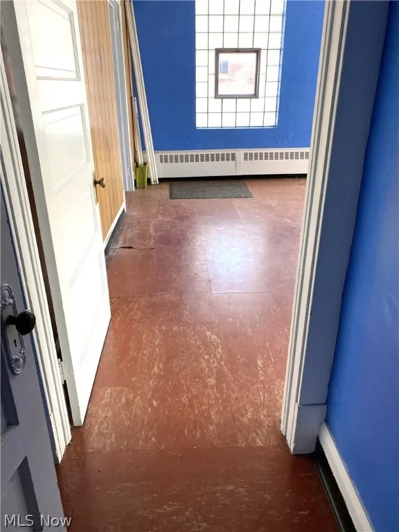 Hallway featuring tile patterned floor.