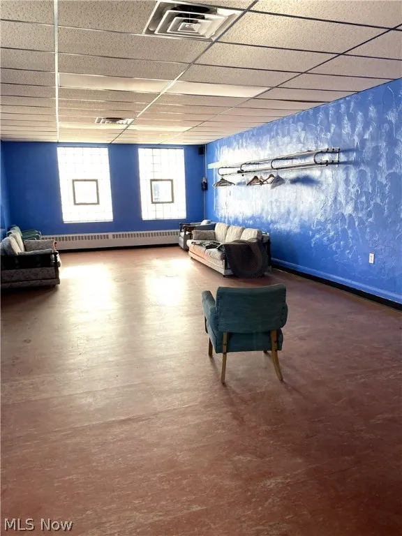 Front room featuring blue walls and drop ceiling.
