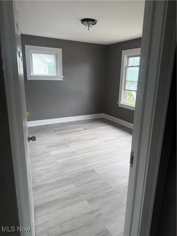 Empty room featuring light wood finished floors and baseboards