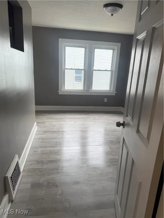 Empty room featuring wood finished floors and a textured ceiling