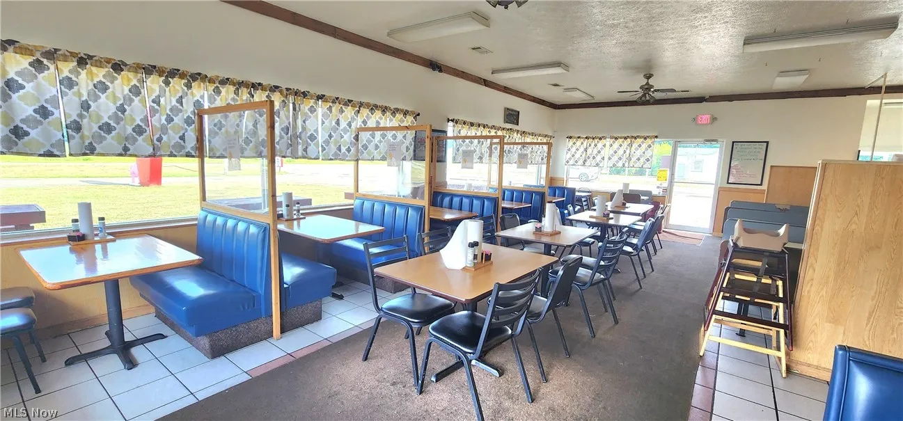 Tiled dining area featuring a textured ceiling, ceiling fan, crown molding, and a healthy amount of sunlight