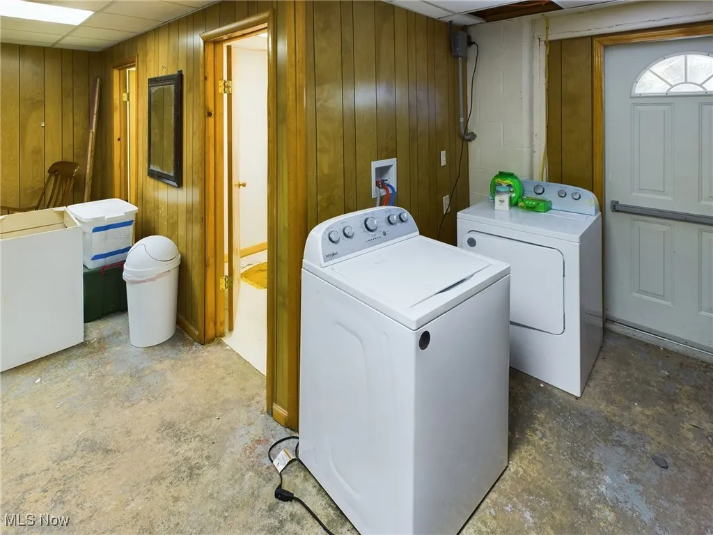 Laundry room with wood walls and washing machine and dryer