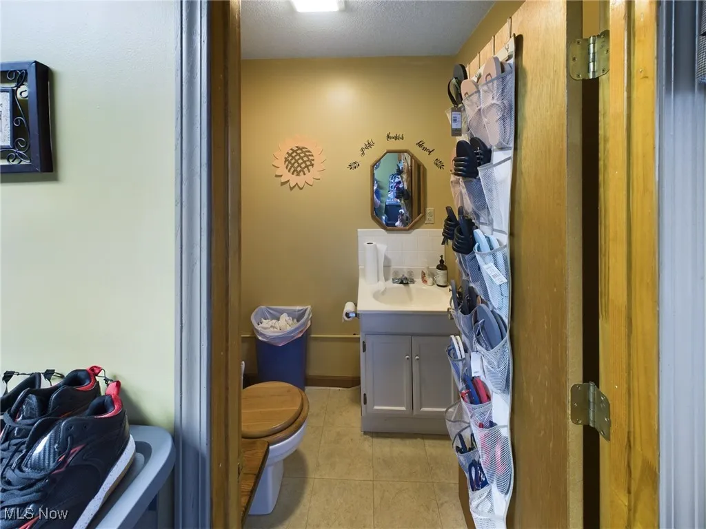 Bathroom with vanity, a textured ceiling, toilet, and tile patterned floors