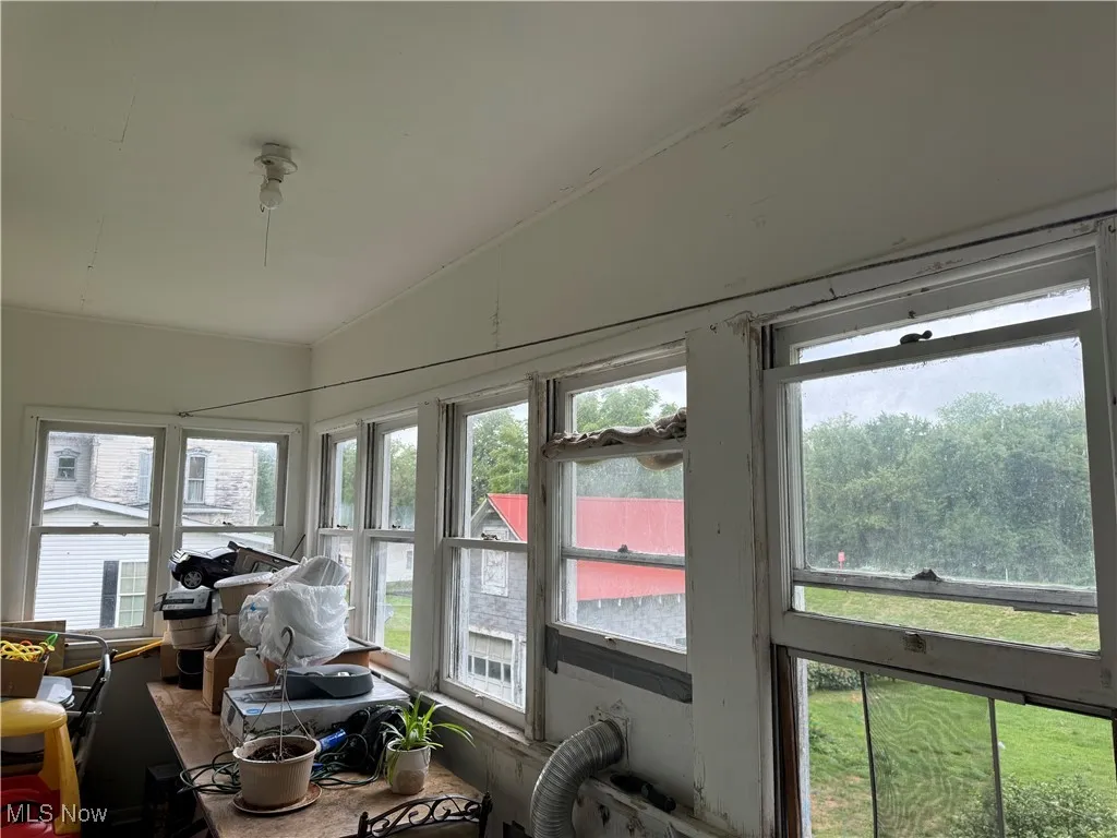 Sunroom / solarium with a healthy amount of sunlight and vaulted ceiling
