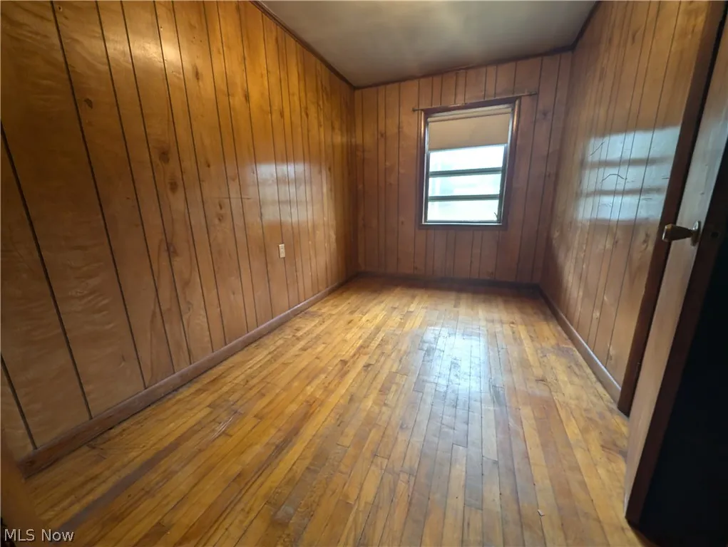 Empty room with wooden walls and wood-type flooring