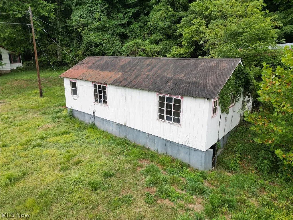 View of home's exterior with a yard and an outbuilding