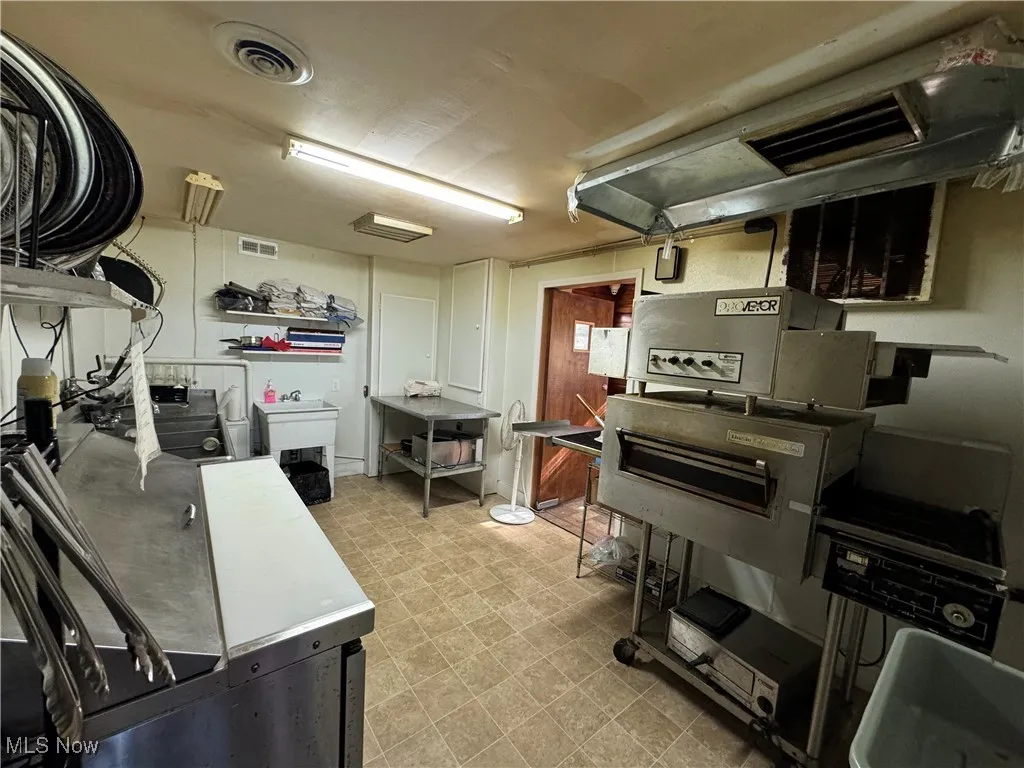 Kitchen featuring white cabinetry, sink, and light tile patterned floors