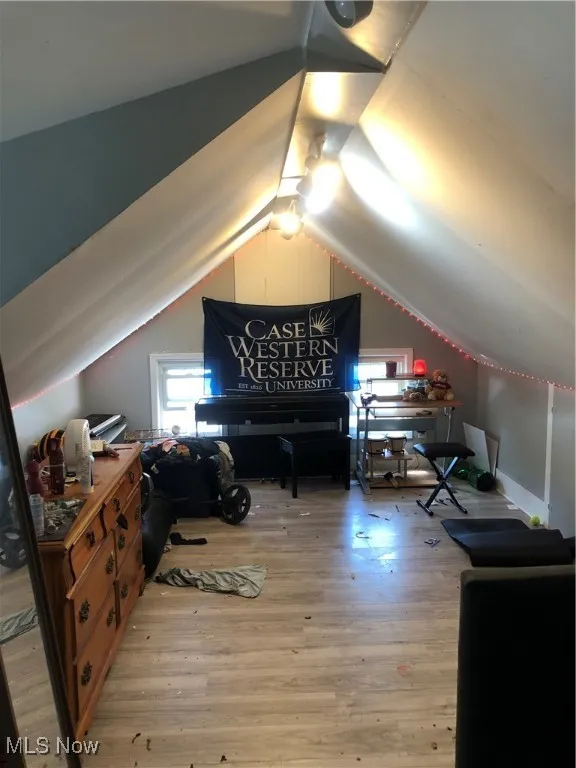 Bedroom featuring wood-type flooring and lofted ceiling
