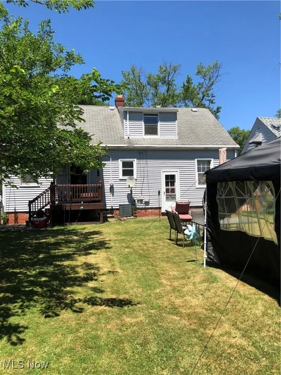 Back of property featuring a deck and a yard