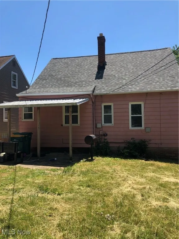 Back of property featuring a yard