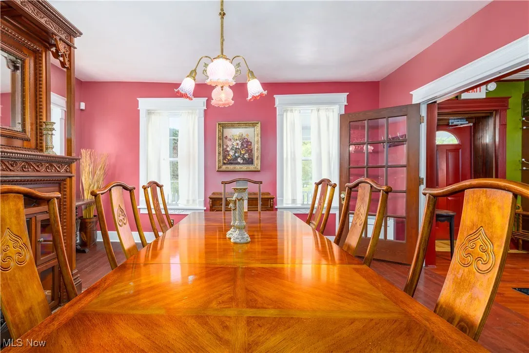Dining room featuring a wealth of natural light, hardwood / wood-style floors, and a notable chandelier
