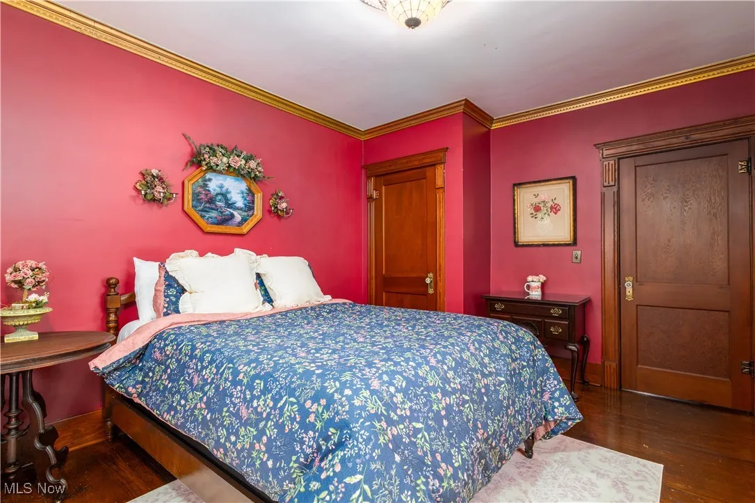 Bedroom featuring crown molding and dark hardwood / wood-style floors