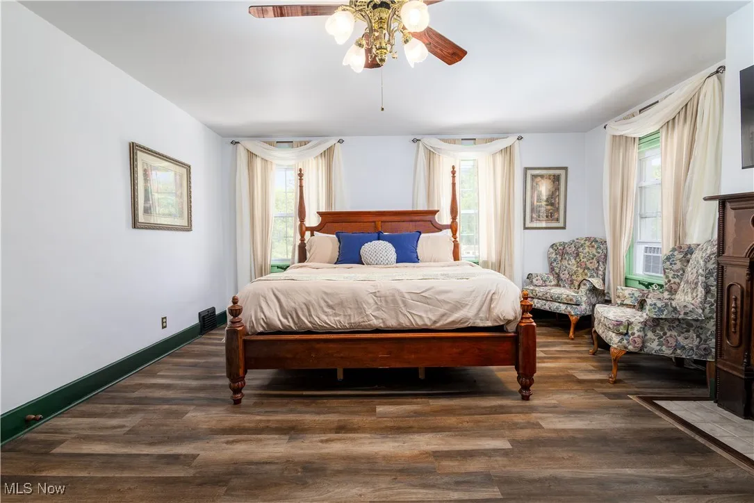 Bedroom with dark hardwood / wood-style flooring and ceiling fan