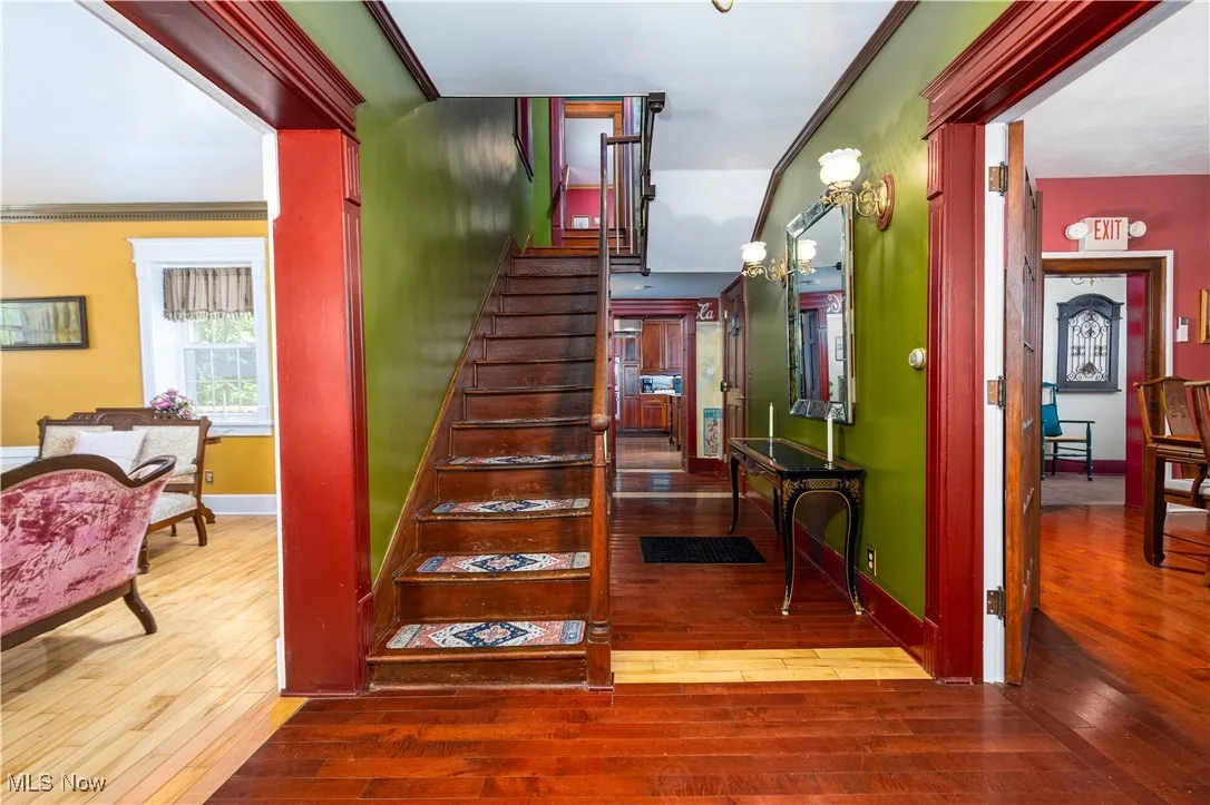 Stairs featuring ornamental molding and hardwood / wood-style flooring