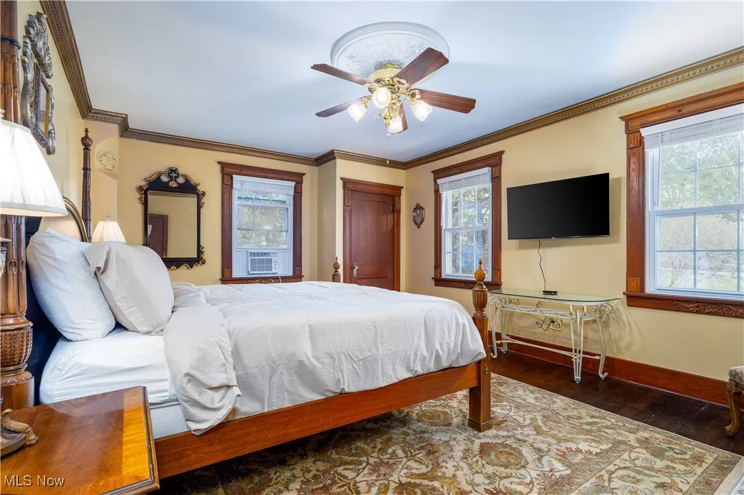 Bedroom featuring cooling unit, ceiling fan, crown molding, and hardwood / wood-style flooring