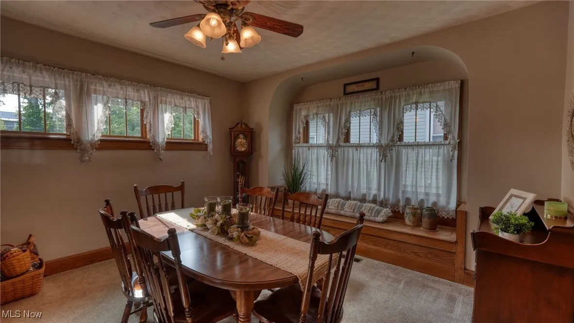 Carpeted dining area with ceiling fan