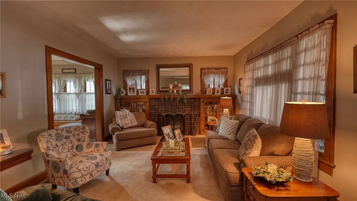 Living room featuring carpet and a brick fireplace