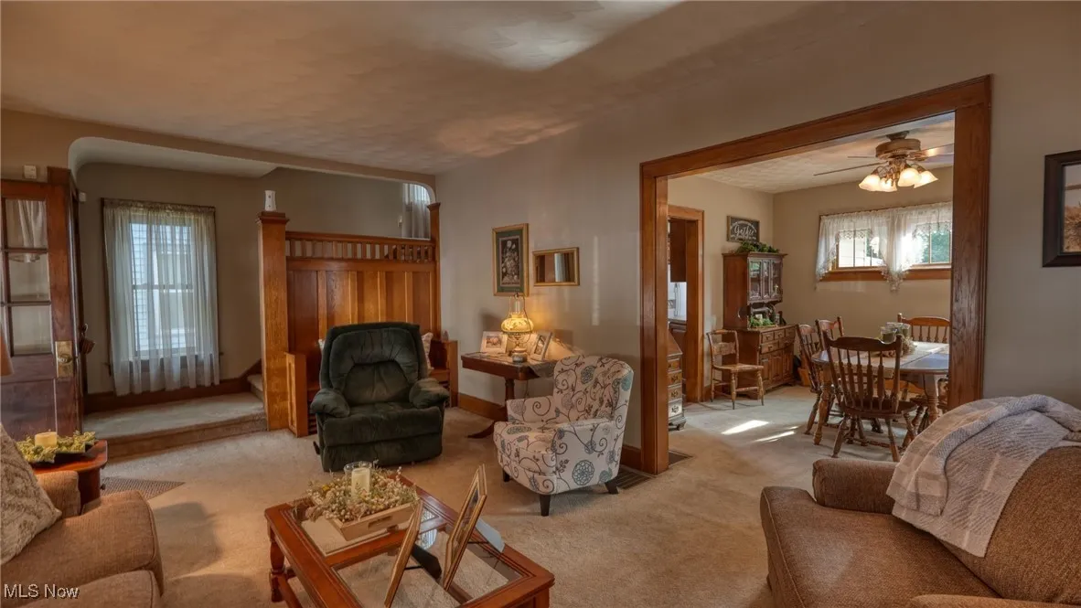 Living room with ceiling fan and light carpet