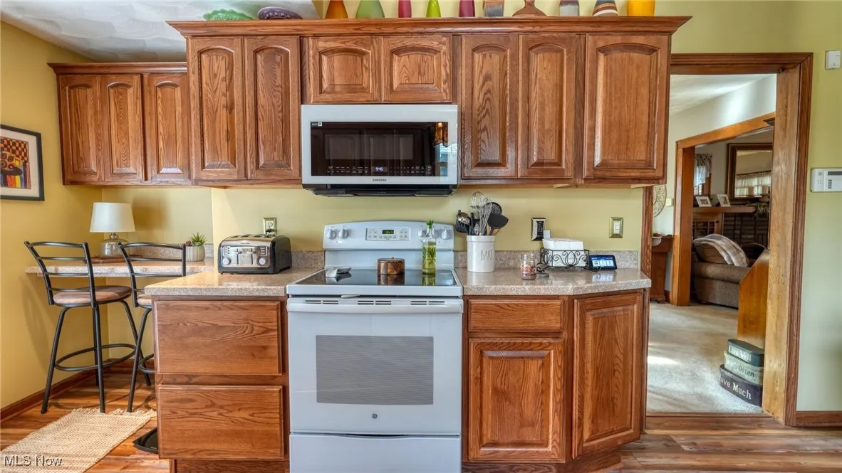 Kitchen featuring hardwood / wood-style flooring and white electric range