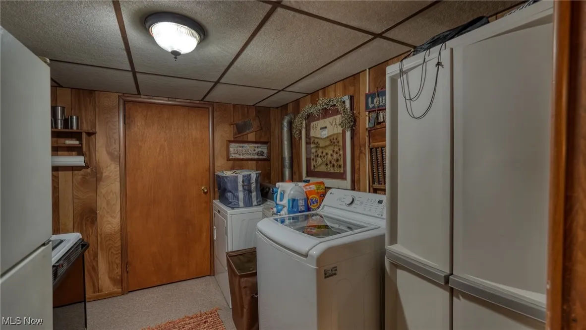 Laundry room with wooden walls and washing machine and clothes dryer