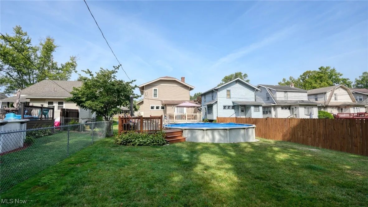 Rear view of house featuring a lawn and a swimming pool side deck