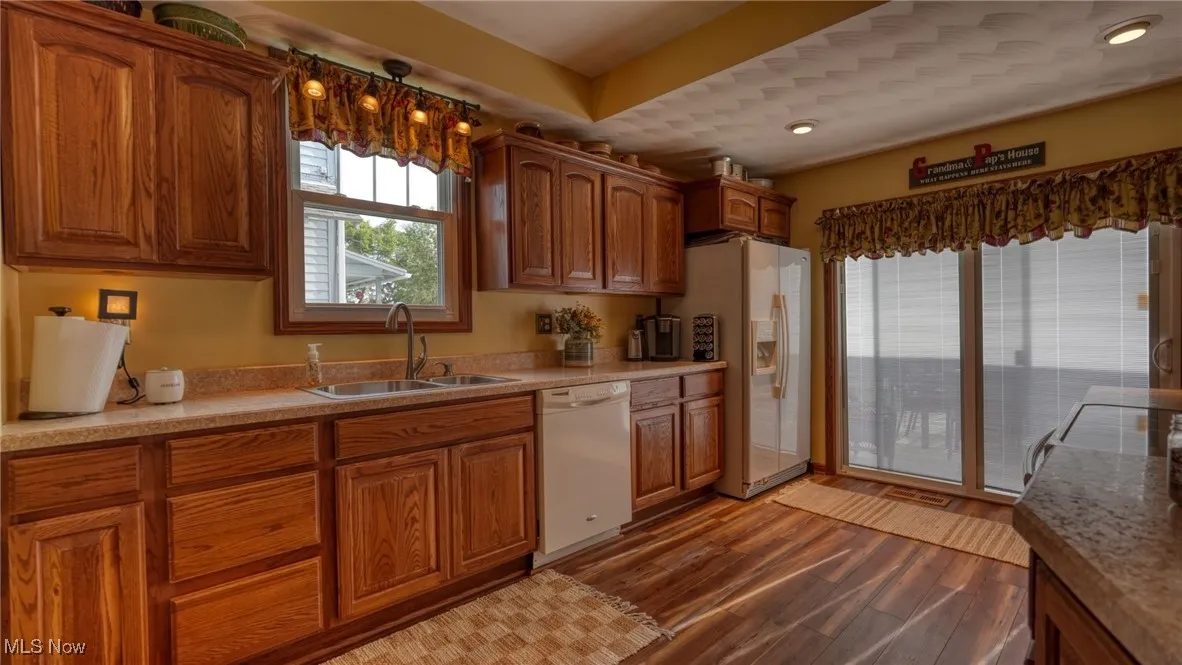 Kitchen featuring sink, white appliances, and light hardwood / wood-style floors