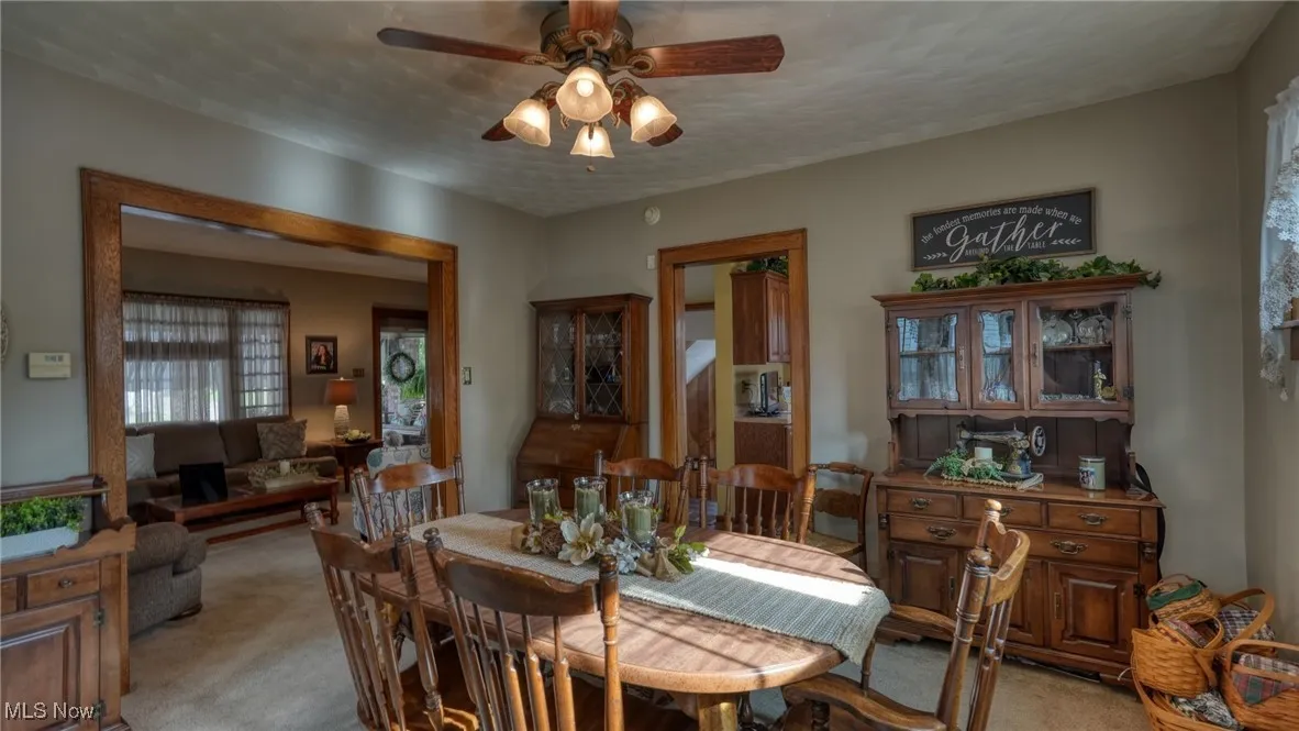 Carpeted dining space featuring ceiling fan