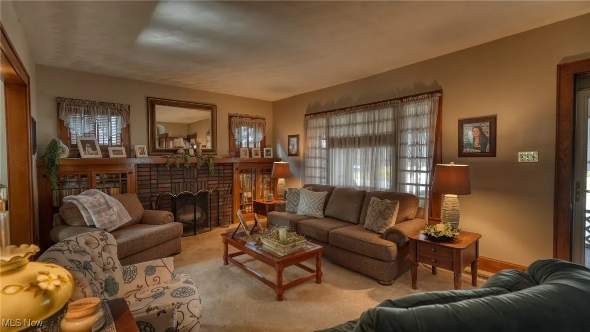 Carpeted living room with a brick fireplace