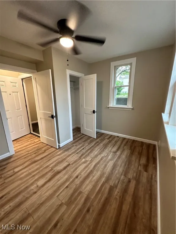 Unfurnished bedroom featuring light hardwood / wood-style floors, ceiling fan, and a closet
