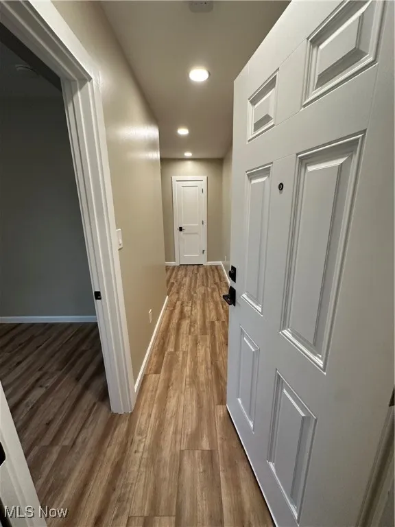 Hall with hardwood / wood-style flooring