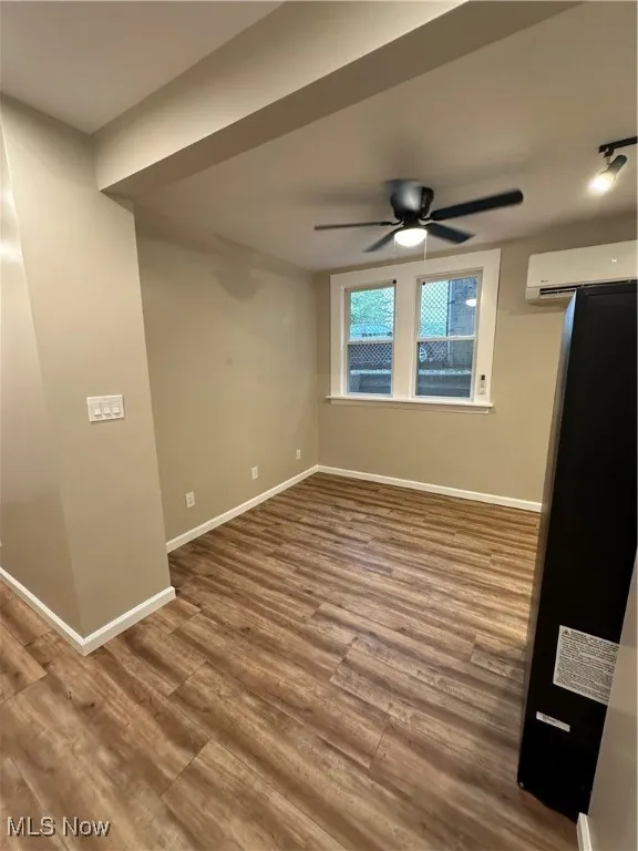 Living area featuring ceiling fan, hardwood / wood-style floors, and a wall mounted air conditioner