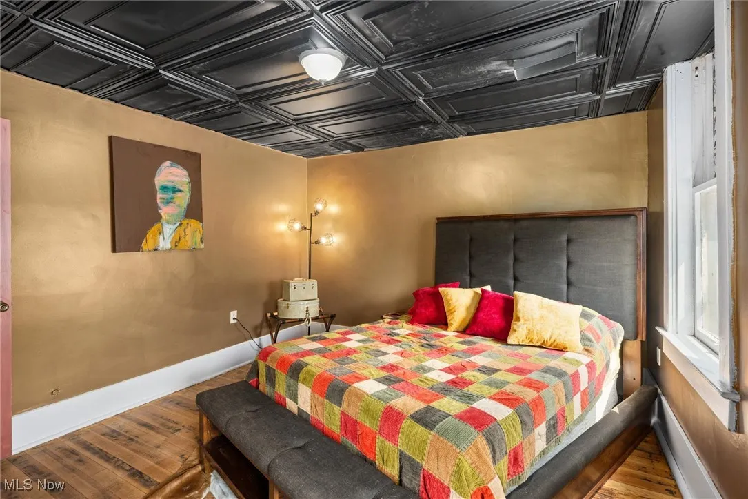 Bedroom with hardwood / wood-style flooring and coffered ceiling