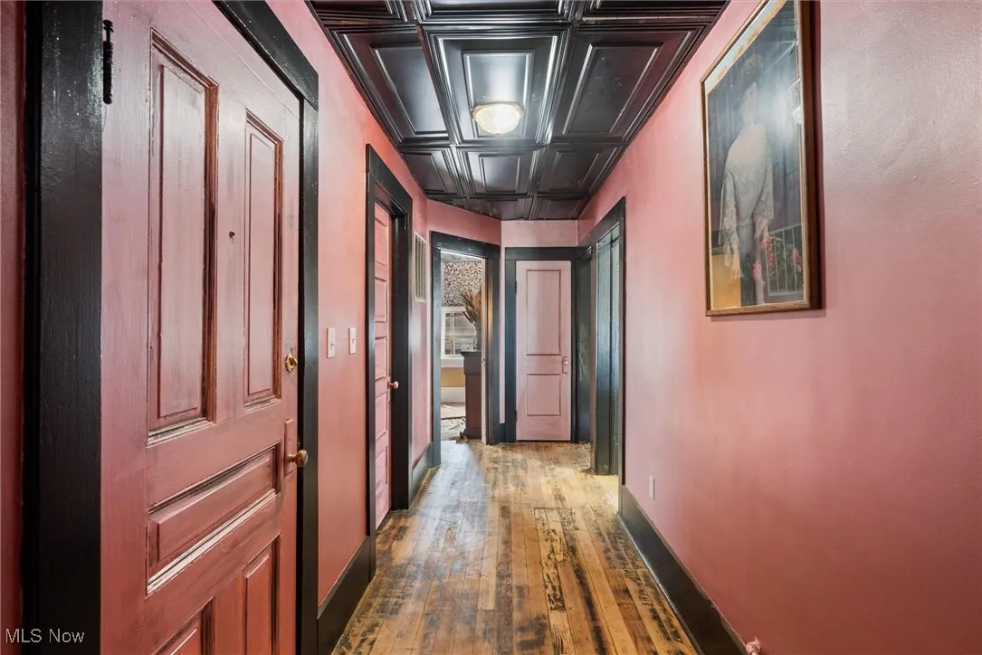 Hallway with ornamental molding, hardwood / wood-style flooring, and coffered ceiling