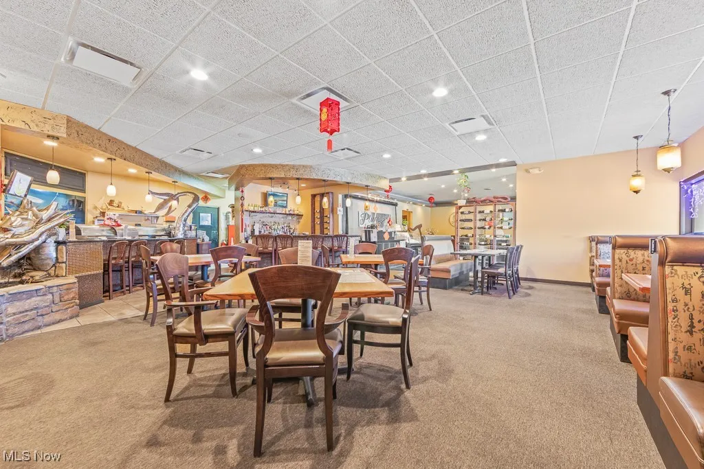 Dining space with a drop ceiling and light carpet
