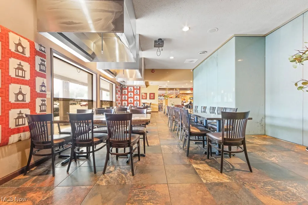 Dining area featuring dark tile patterned flooring and a textured ceiling