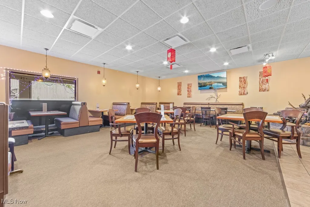 Carpeted dining area with a paneled ceiling