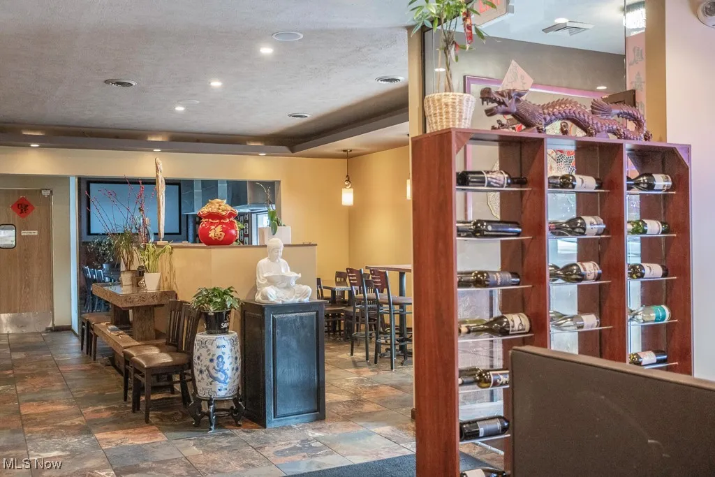 Wine area with a raised ceiling, a textured ceiling, and dark tile patterned floors