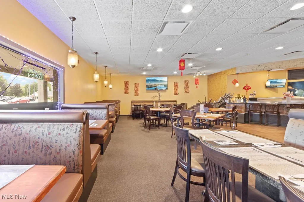 Carpeted dining room featuring bar and a paneled ceiling