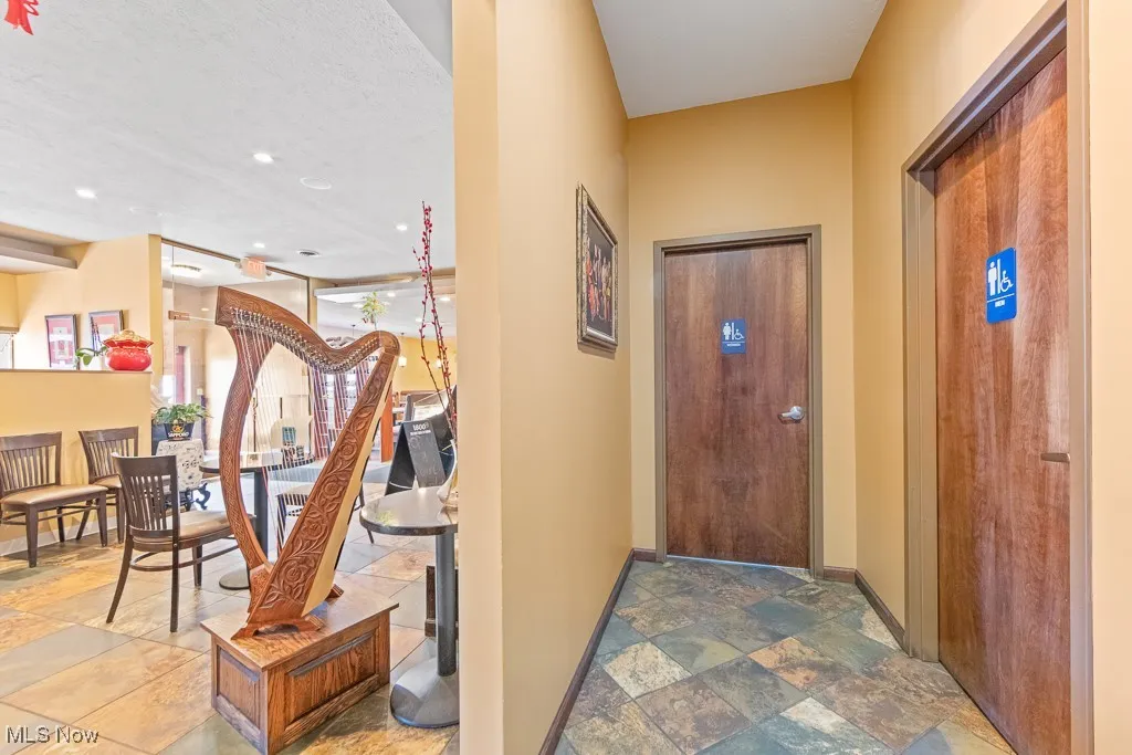 Corridor with a textured ceiling and tile patterned flooring